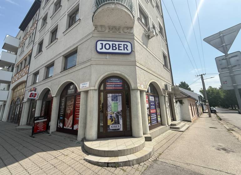 Obchodní prostory v Komárně na Petőfiho ulici se sluneční fasádou a reklamními štíty.