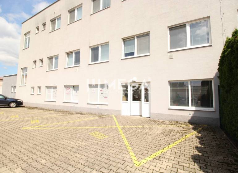 Obchodní prostory na Tolstého ulici v Humenném se vstupními dveřmi a parkovištěm.