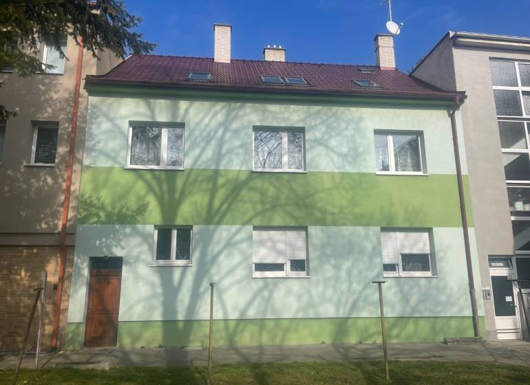 Rodinný dům na Kalinčiakově ulici v Piešťanech, zelená fasáda, stín stromu.