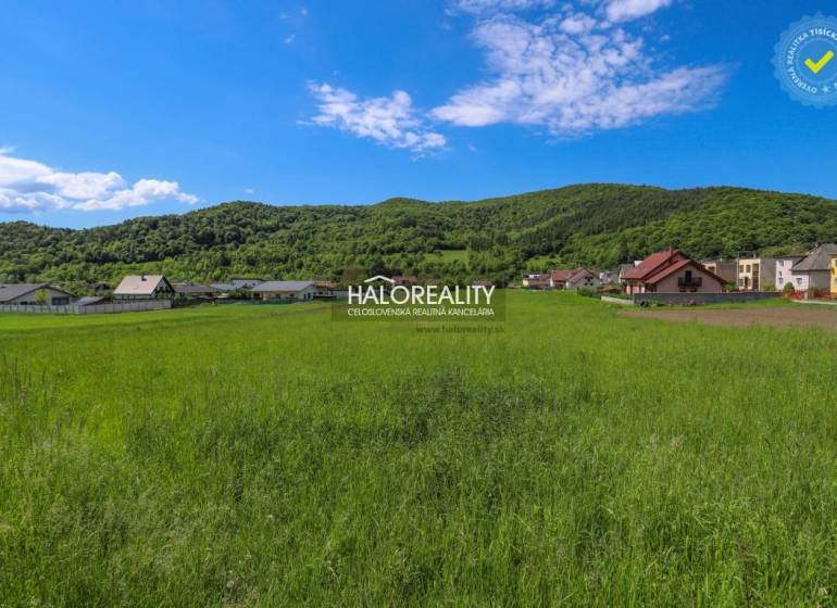 Zeleň a panorama v Udiči, pozemky - bydlení s domy a zalesněnými kopci v pozadí.