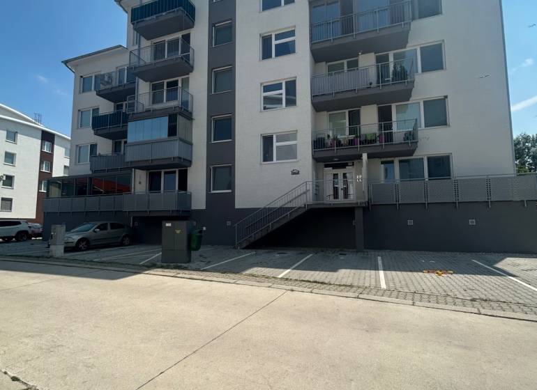 Pětipatrový bytový dům se schodištěm a parkovištěm na Slavomírově ulici ve Slovenském Grobu.