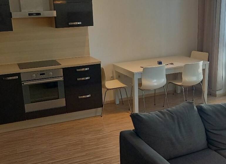 Kuchyně a obývací pokoj v 2pokojovém bytě s moderní kuchyňskou linkou a jídelním stolem.