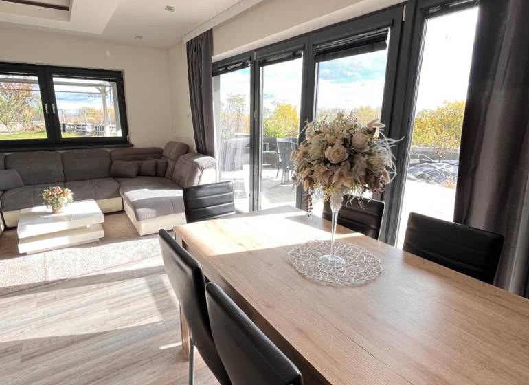 Obývací pokoj rodinného domu s podlahou s dřevěným dekorem a komfortním sezením.