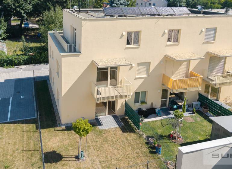 Žlutý bytový dům na Železniční ulici v Bratislavě-Vrakuni se zahradou a parkovacími místy.