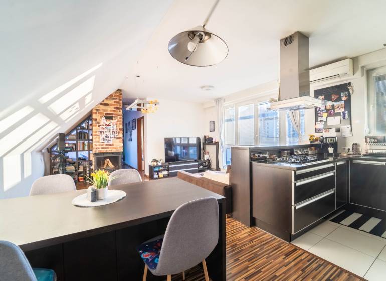 Kuchyně s televizorem, krbem a podlahou s dřevěným dekorem v 2-pokojovém bytě.