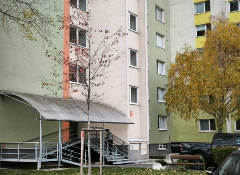 Panelový bytový dům na Korytnické ulici, Bratislava - Podunajské Biskupice, obklopený zelení.