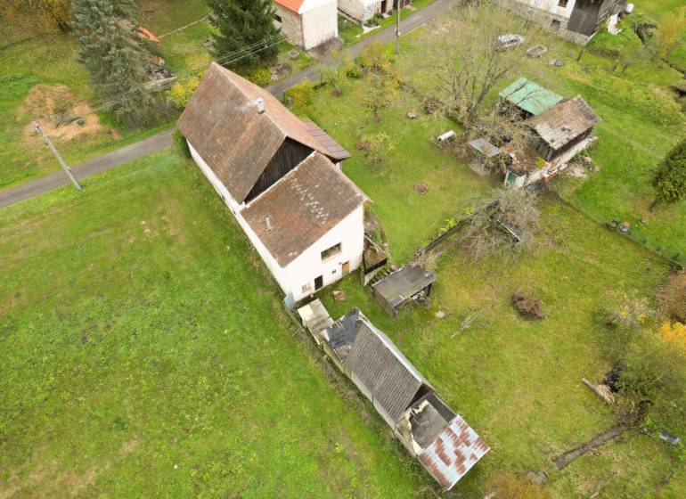 Rodinný dům na Sklené ve Sklené obklopený zahradou, s vedlejšími stavbami a stromy.