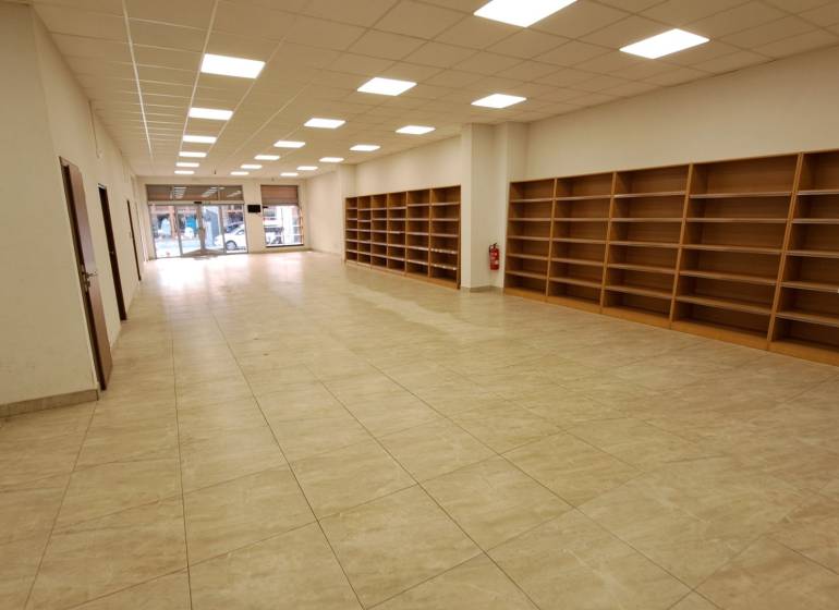 Obchodní prostory k pronájmu na Mostové ulici v Ružomberku, s regály a podlahou s dřevěným dekorem.