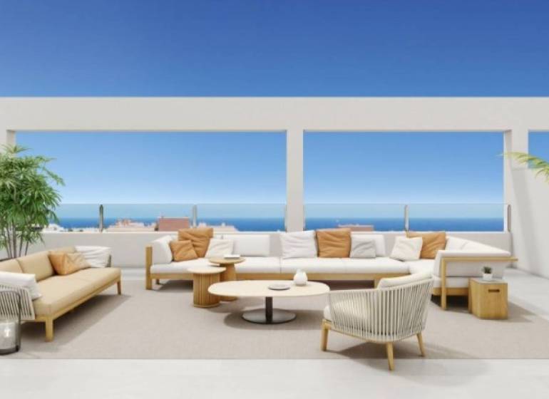 Terasa rekreačního apartmánu v Torrevieja s posezením, oceán a modrá obloha v pozadí.