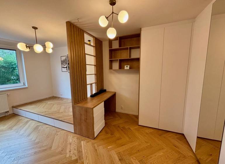 Interiér 2-pokojového bytu s podlahou s dřevěným dekorem a minimalistickými svítidly.