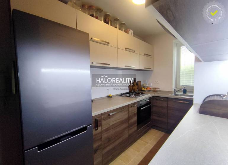 Kuchyně v 3-pokojovém bytě s podlahou s dřevěným dekorem a moderními spotřebiči.