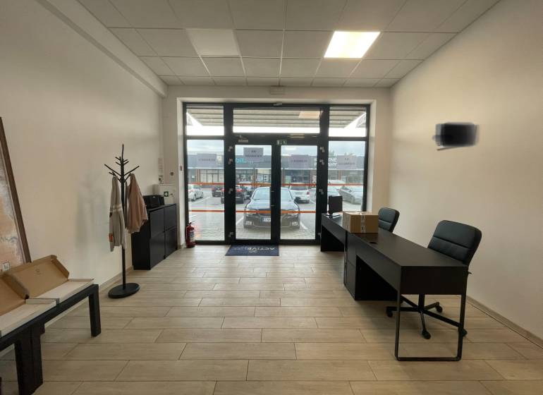 Interiér obchodních prostor s nábytkem a podlahou s dřevěným dekorem.