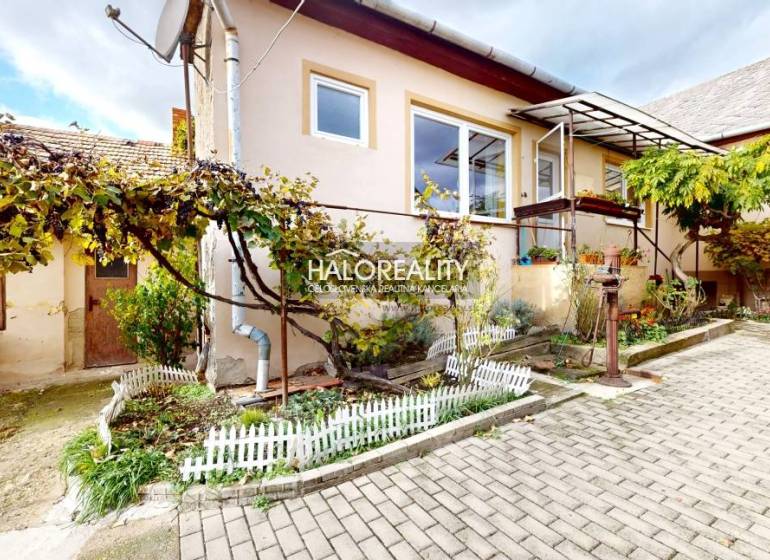 Rodinný dům v Lučenci s předzahrádkou, vinnou révou a dlažbou na dvoře.