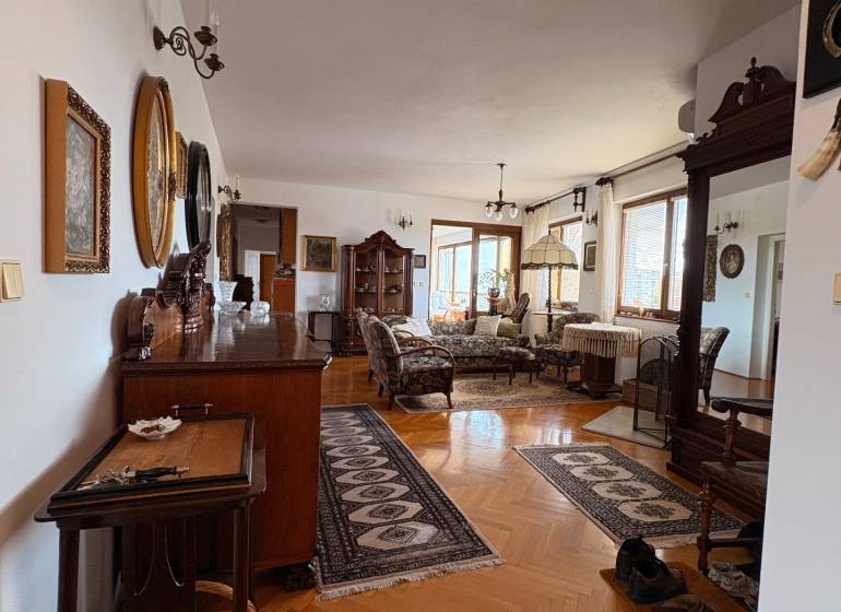 Pětipokojový byt s podlahou s dřevěným dekorem, klasický nábytek a koberce.