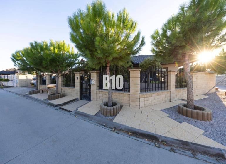 Rodinný dům v Mostě u Bratislavy s kamenným plotem a výsadbou stromů.