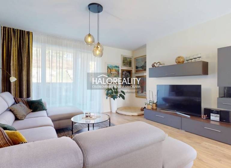 Obývací pokoj v rodinném domě s pohodlnou sedačkou a podlahou s dřevěným dekorem.