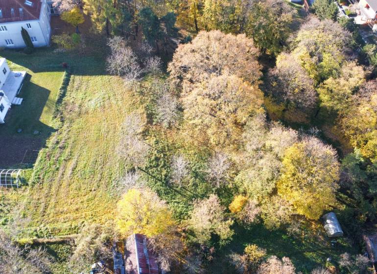 Letecký pohled na pozemky - komerční v Suchej nad Parnou, obklopené zelení a budovami.