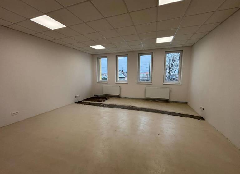 Kanceláře s bílými stěnami, podlahou a okny, čekající na dokončení.