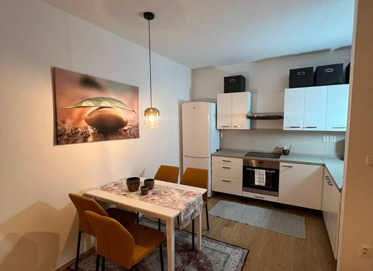 Kuchyně a jídelna v 2-pokojovém bytě s podlahou s dřevěným dekorem.