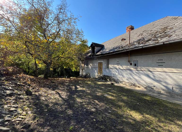 Dvorec s domem v Rákoši, obklopený zelení. Pozemky - bydlení.