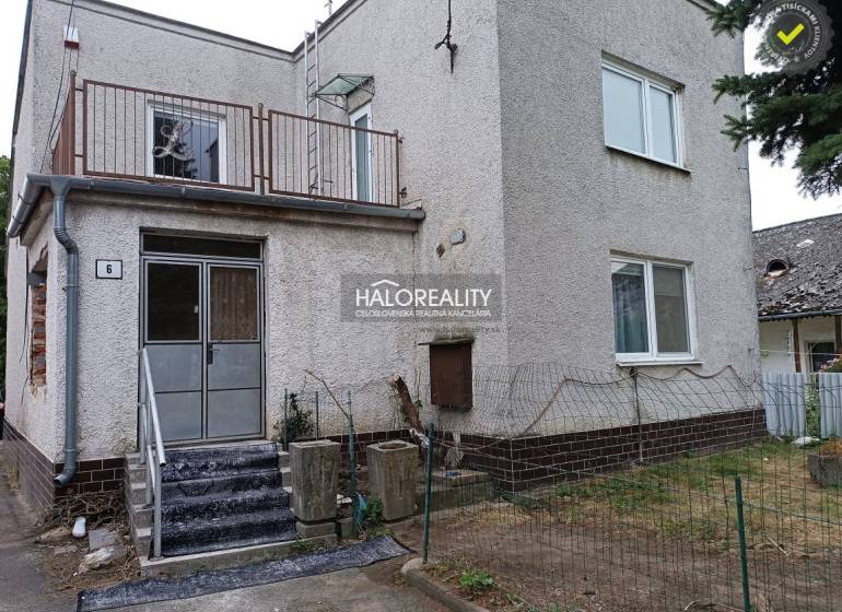 Rodinný dům na Zemplíně se schodištěm, balkonem a řídkým plotem.