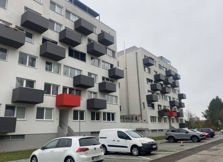 Bytovka na Lomnické ulici v Nitře s garážovými stáními a balkóny.