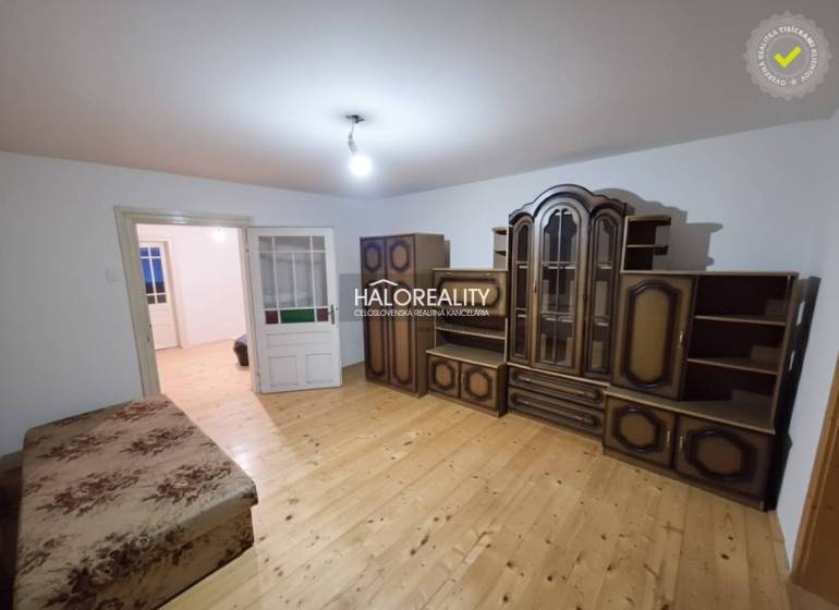 Pokoj v rodinném domě s nábytkem a podlahou s dřevěným dekorem.