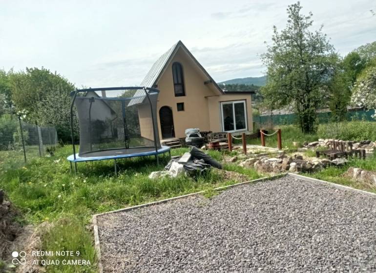 Chata v Hliníku nad Hronom s trampolínou a kamenitou cestou v zahradě.