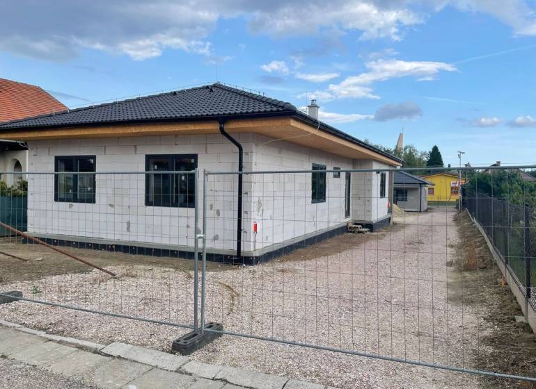 V Radavě probíhá výstavba rodinného domu se šikmou střechou a bílou fasádou.