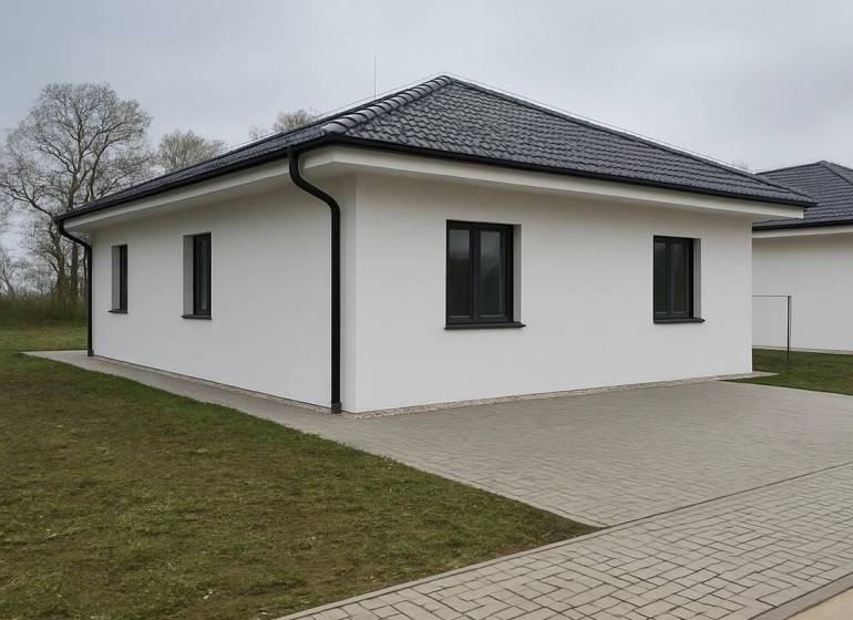 Rodinný dům v Cíferi se šikmou střechou a dlážděným chodníkem.