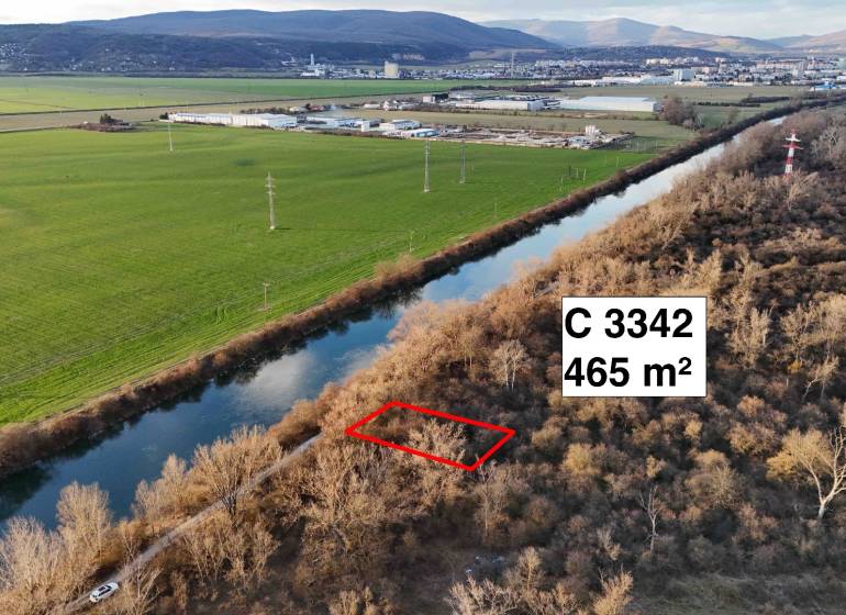 Letecký pohled na rekreační pozemky v Nová Ves nad Váhom u řeky a lesíku.