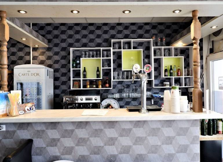 Barový pult s nápoji a pivními kohoutky v obchodních prostorách.