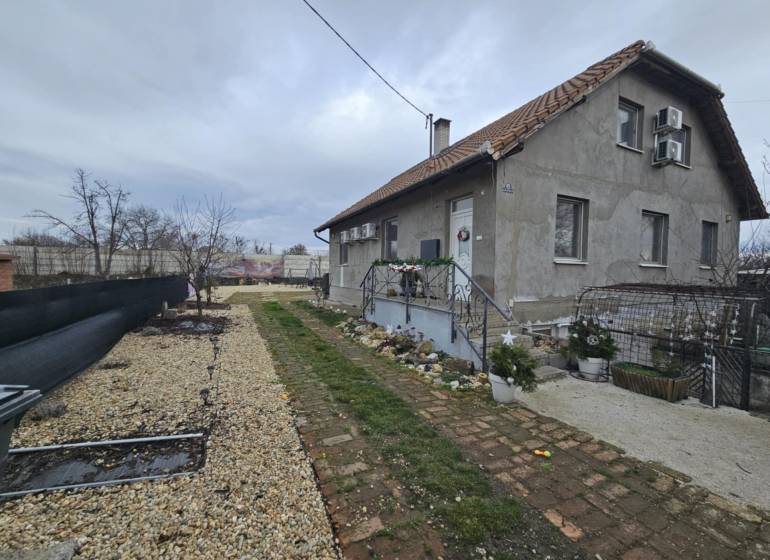 Rodinný dům v Hernádkaku se zahradou, štěrkovou příjezdovou cestou a dřevěnými prvky.