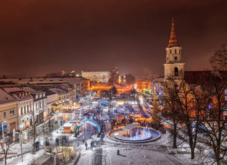 Zimní večerní atmosféra v centru Zvolena se zasněženými střechami a rozsvícenými ulicemi.