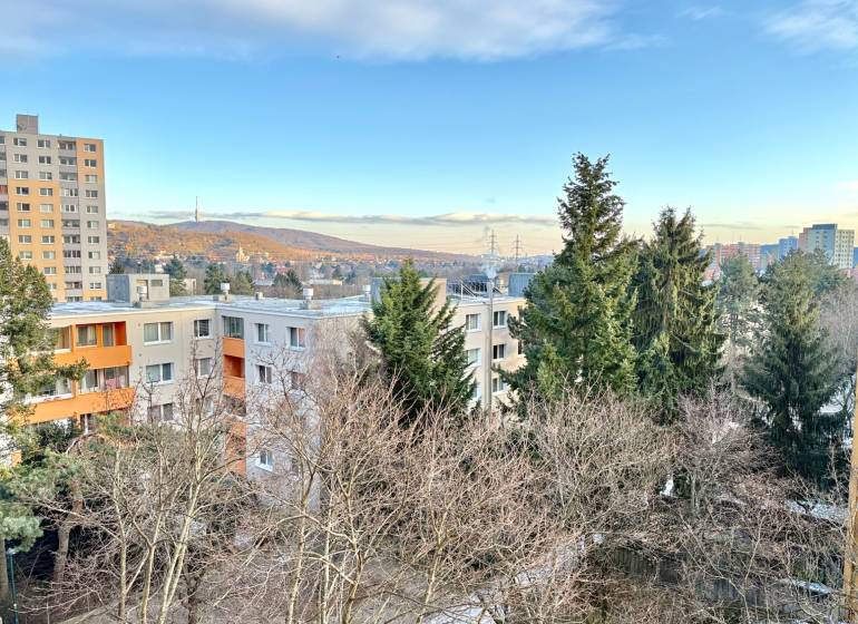 Zobrazená je panoráma bytovek a stromů na Drobného ulici v Bratislavě - Dúbravce.