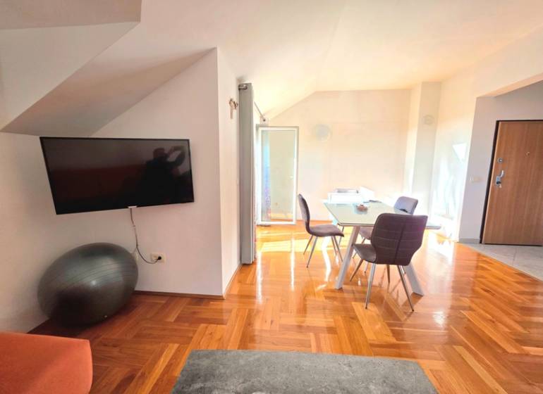 Interiér rekreačního apartmánu s podlahou s dřevěným dekorem a jídelním stolem.