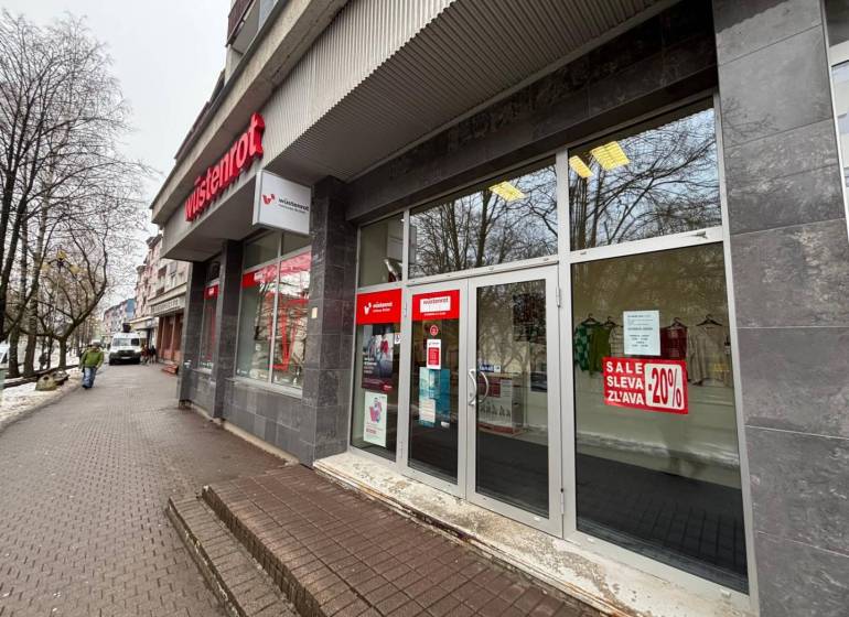 Obchodní prostory v Popradu s velkými skleněnými výlohami, obsahují reklamu na slevy.