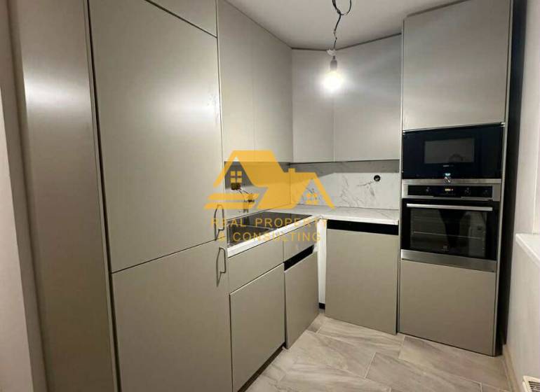 Kuchyně v 2pokojovém bytě s moderními skříňkami a spotřebiči.