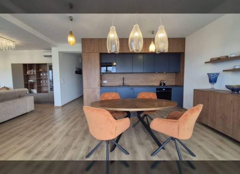 Interiér rekreačního apartmánu s podlahou s dřevěným dekorem a jídelním stolem.