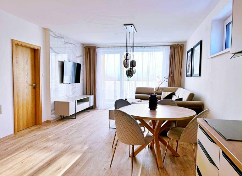 Obývací pokoj ve 3pokojovém bytě se světlým nábytkem a podlahou s dřevěným dekorem.