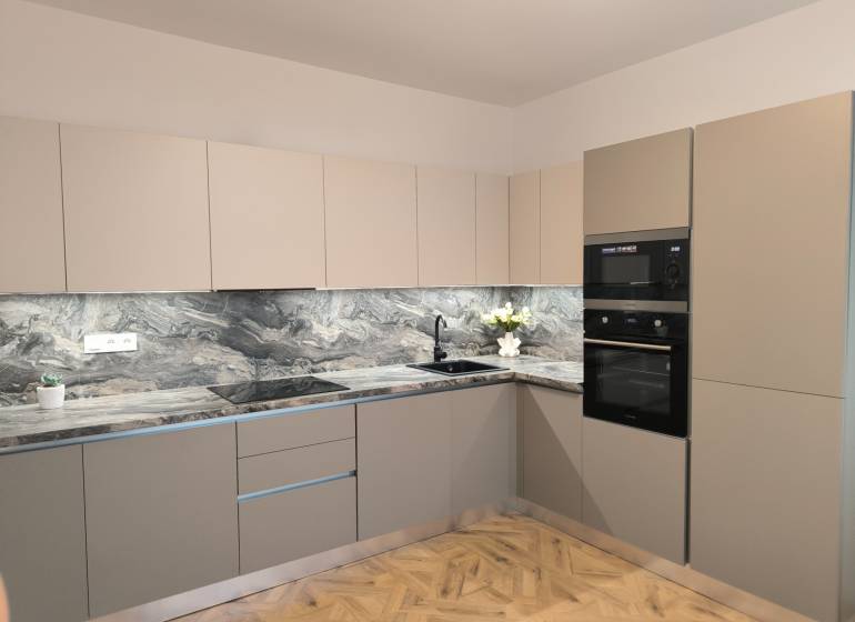 Kuchyně ve 4pokojovém bytě s mramorovou pracovní deskou a podlahou s dřevěným dekorem.