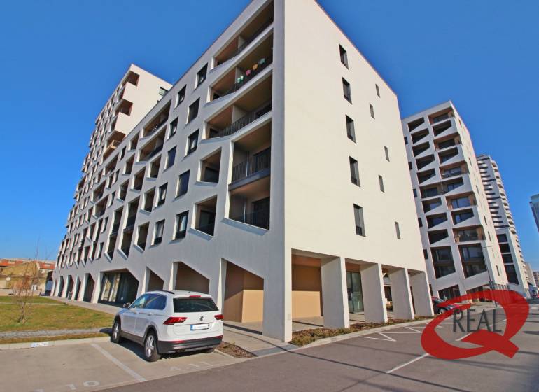 Budova s parkovištěm v Bratislavě-Petržalce na ulici Závodu Matador se zaparkovaným autem.