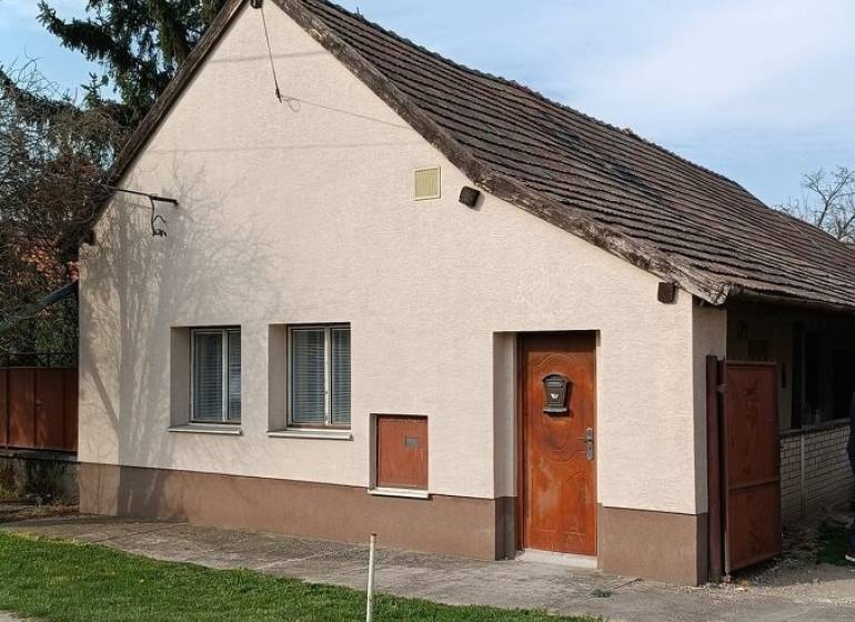 Rodinný dům v Horních Salibách s bílou fasádou a šikmou střechou.