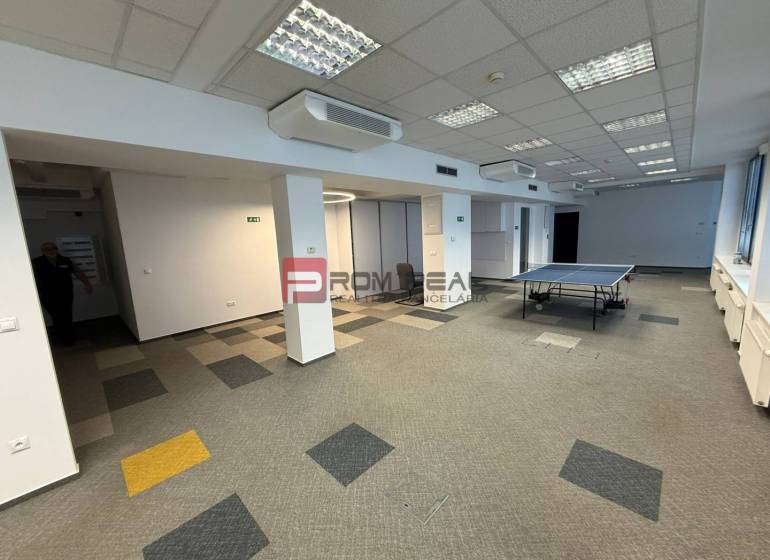 Kanceláře s kobercem a stolním tenisem, prostorné prostředí pro aktivity.
