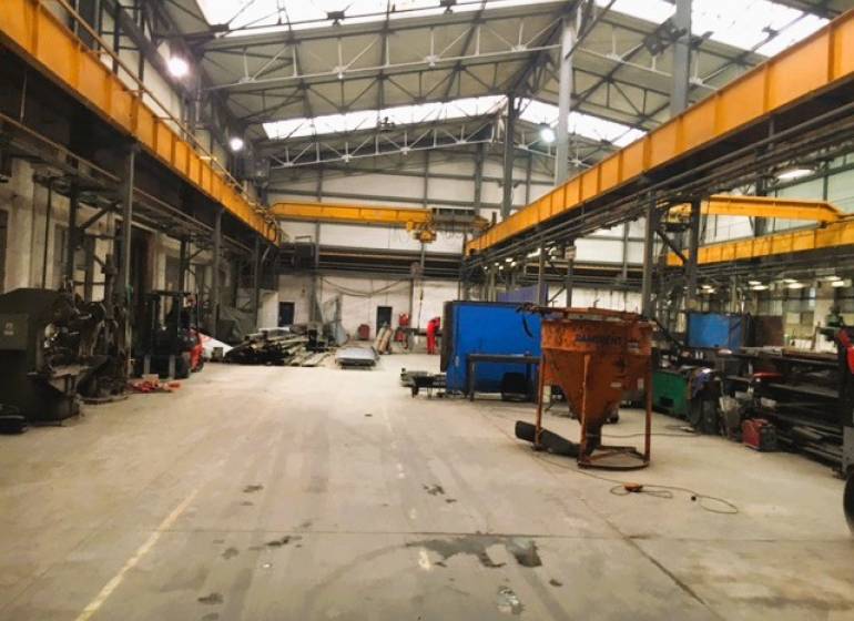 Výrobní prostory ve Spišské Nové Vsi s vysokými stropy a průmyslovým vybavením.