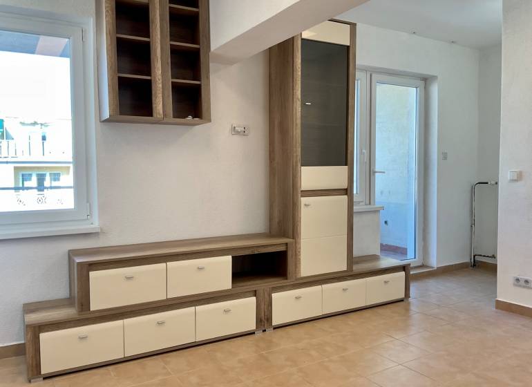 Obývací prostor v 1-pokojovém bytě s nábytkem a keramickou podlahou.