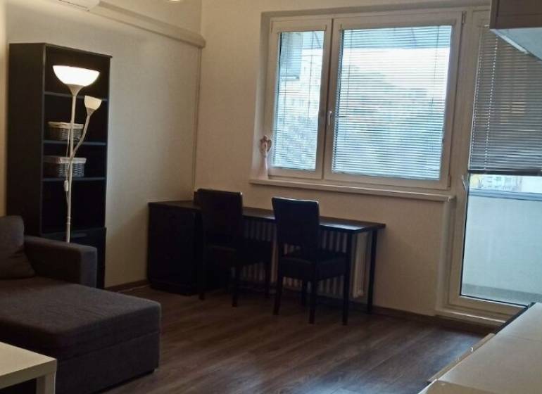 Obývací pokoj v 2-pokojovém bytě s rohovou sedačkou a podlahou s dřevěným dekorem.