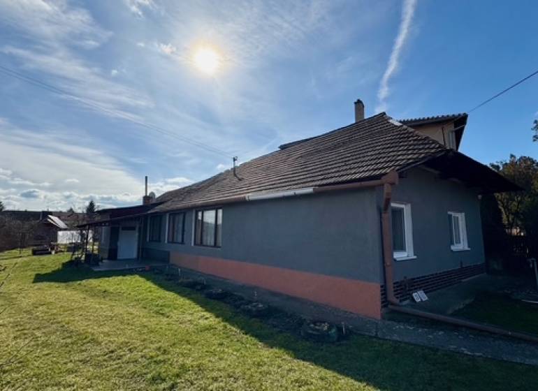 Rodinný dům v Mýtných Ludanoch s travnatou zahradou a cihlovou fasádou.