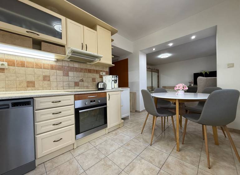 Kuchyně s kuchyňskou linkou a jídelním stolem v 2-pokojovém bytě.