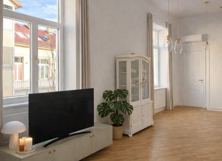 Obývací pokoj v 3-pokojovém bytě s podlahou s dřevěným dekorem, televizorem a velkými okny.